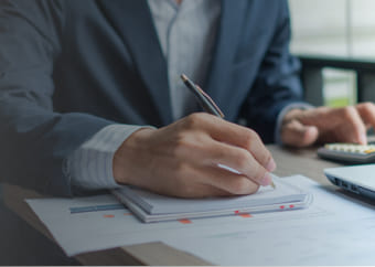 Man using a calculator and writing on a paper.