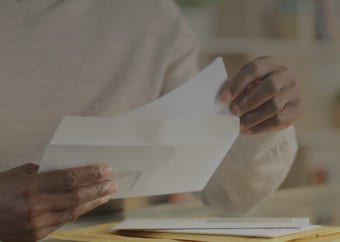 Man opening an envelope and taking out a bill