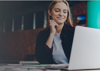 Woman looking happily at her computer screen