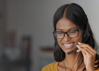 Woman talking through a headset while smiling 