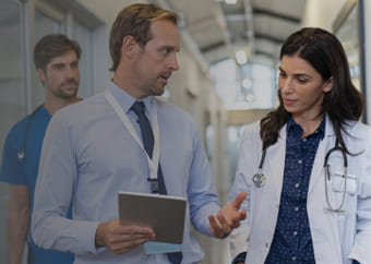 Medical doctors discussing while walking in a hospital hallway