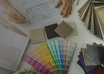 Designer working on a house blueprint with color paletes and fabrics