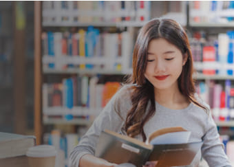 Young woman reading a book at the library