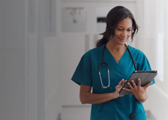 Doctor in scrubs checking her ipad