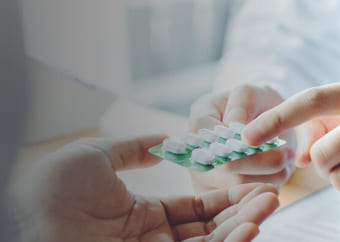 Pharmacist handing pills to a patient