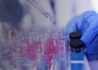 Scientist puting chemical inside a test tube with a dropper