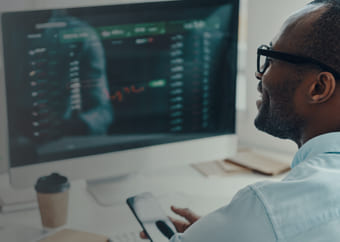 Man looking a stock graphs in a computer