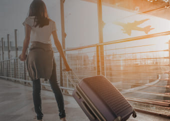 Woman at an airport pulling her suitcase